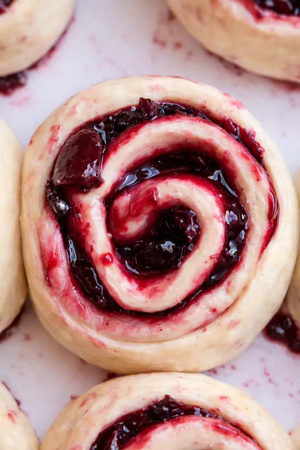 Cherry cinnamon rolls with glossy cherry filling in soft swirled dough