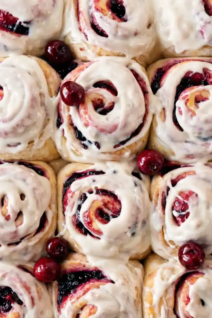Cherry cinnamon rolls with cream cheese frosting and cherry filling swirls