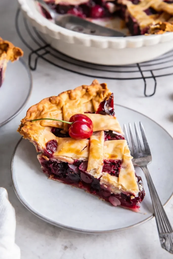 Cherry Pie slice with flaky crust and juicy cherry filling on plate