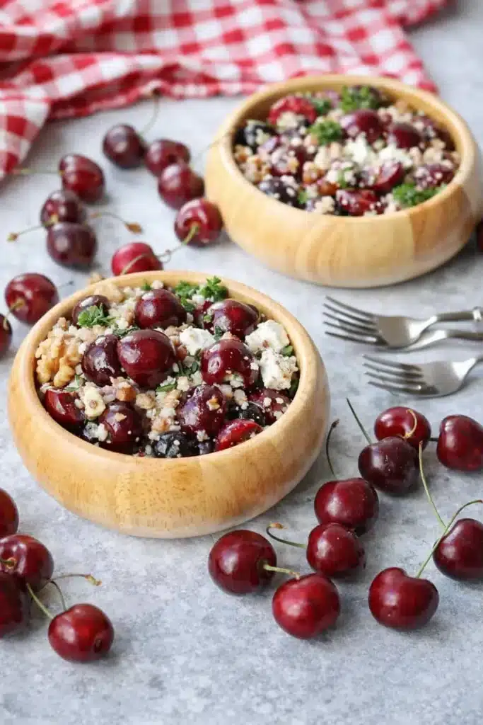 Cherry Walnut Couscous Salad served in rustic bowls with fresh cherries and feta