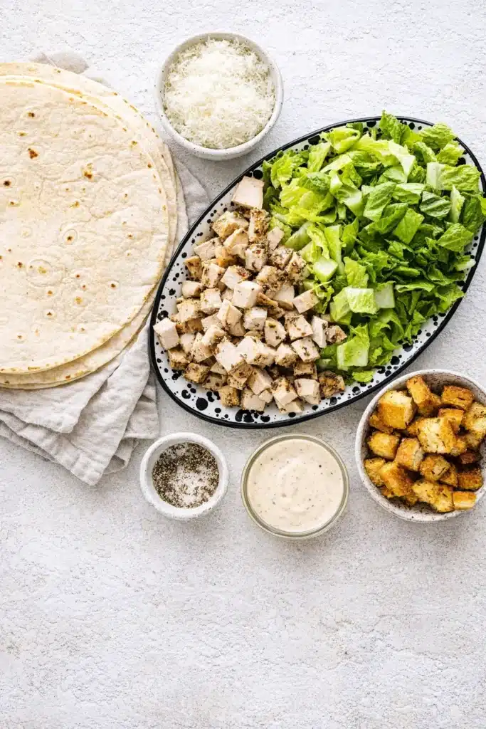 Chicken Caesar Wrap Quick Amazing Dinner 5 Chicken Caesar Wrap ingredients with tortillas, chicken, lettuce, dressing, and croutons