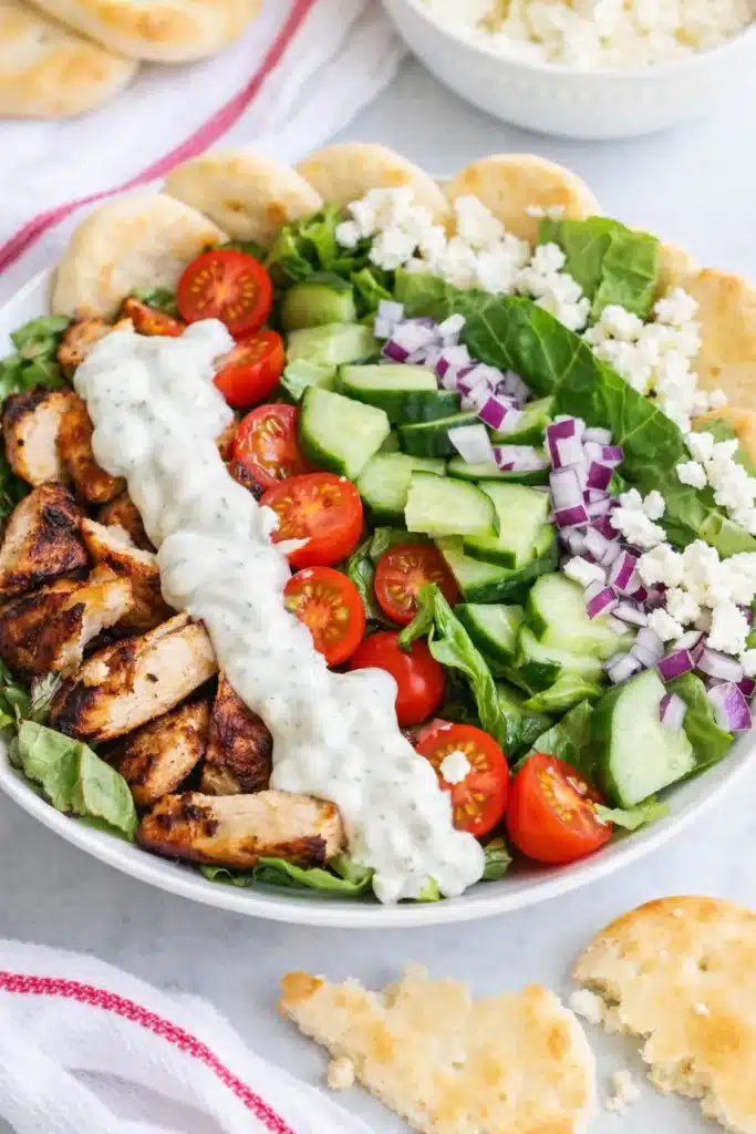 Chicken shawarma bowl with grilled chicken, fresh vegetables, feta cheese, and tzatziki sauce