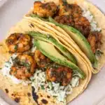Cilantro lime shrimp tacos with avocado and creamy slaw on corn tortillas