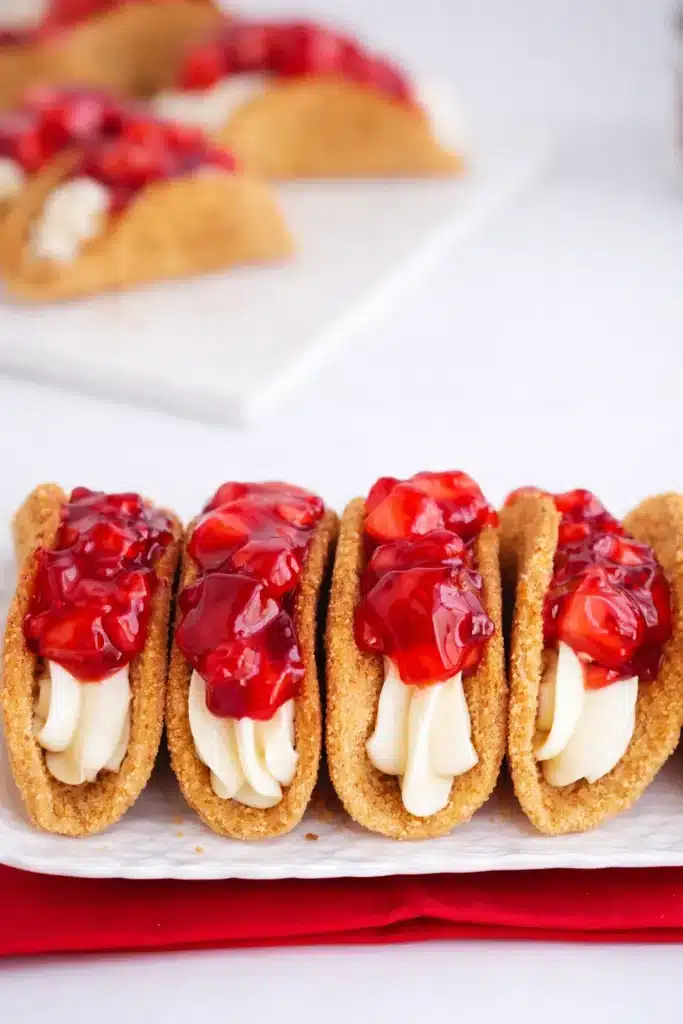 Cheesecake Tacos Easy Amazing Dessert Recipe 6 Cheesecake tacos with creamy filling and strawberry topping close-up