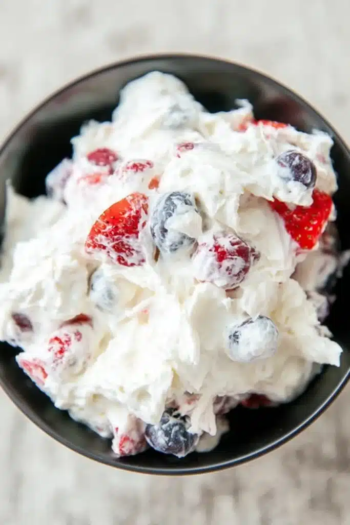 Cheesecake salad with fresh berries in a creamy fluffy mixture