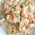 Creamy shrimp salad with fresh dill, celery, and red pepper in a bowl