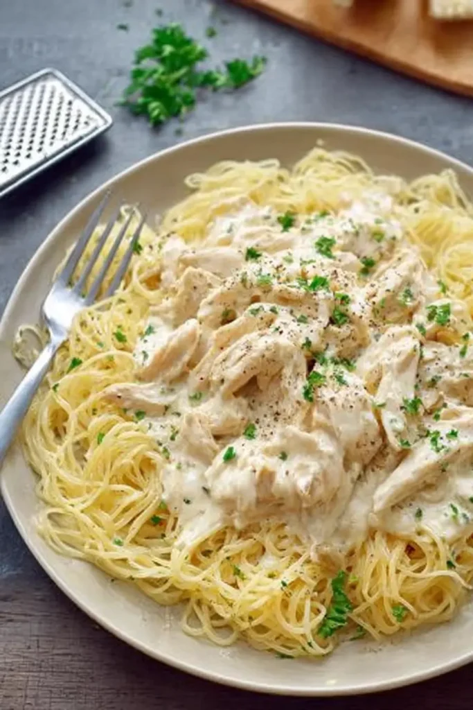 Crock Pot Angel Chicken served over angel hair pasta with creamy sauce