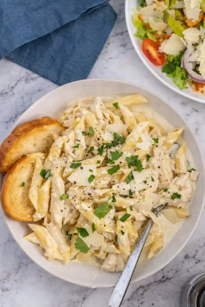 Crockpot Chicken Alfredo served with garlic bread and salad