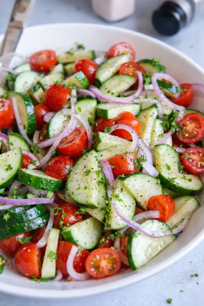 Cucumber Tomato Salad with fresh herbs and red onion in a bowl