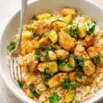 Easy baked chicken and zucchini served over rice with herbs and spices