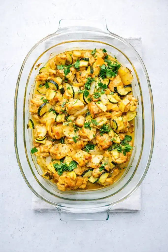 Easy baked chicken and zucchini in glass baking dish with herbs