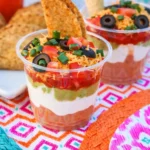 Easy Cinco de Mayo snacks with seven layer dip cups and tortilla chips