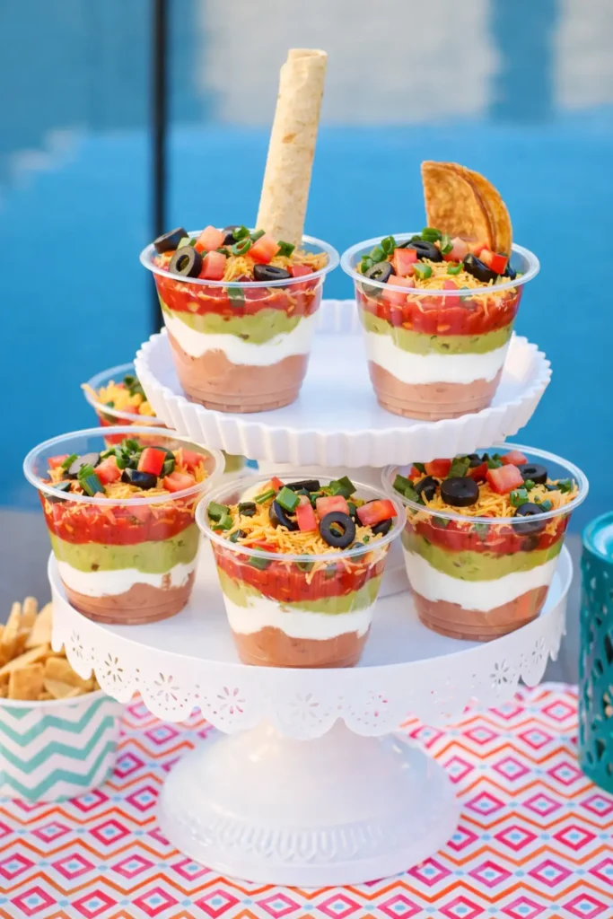 Easy Cinco de Mayo snacks with seven layer dip cups on tiered stand
