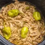 Easy Mississippi chicken with shredded tender meat and pepperoncini peppers in slow cooker