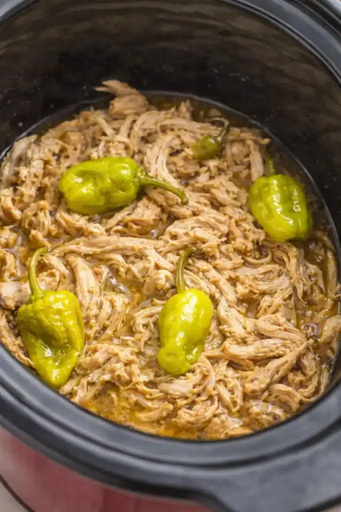 Easy Mississippi chicken with shredded tender meat and pepperoncini peppers in slow cooker