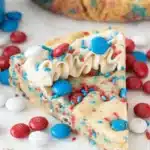 Fireworks sugar cookie cake slice with frosting and red blue candy sprinkles