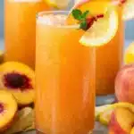 Peach Lemonade Easy Amazing Summer Drink Recipe 7 Peach lemonade in glass with ice, peach slices, lemon, and mint garnish