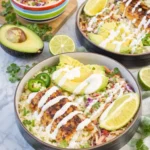 Low carb fish taco bowls with cauliflower rice, avocado, slaw, and creamy lime sauce