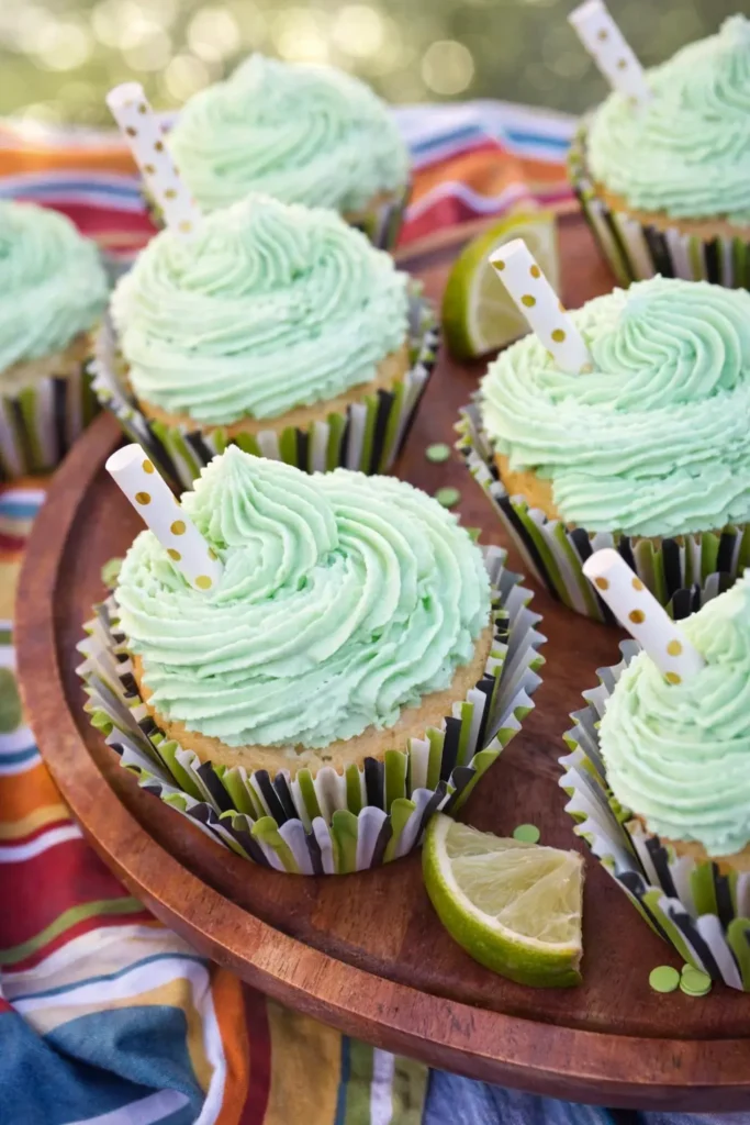 Margarita cupcakes with tequila lime frosting and lime wedges on serving plate
