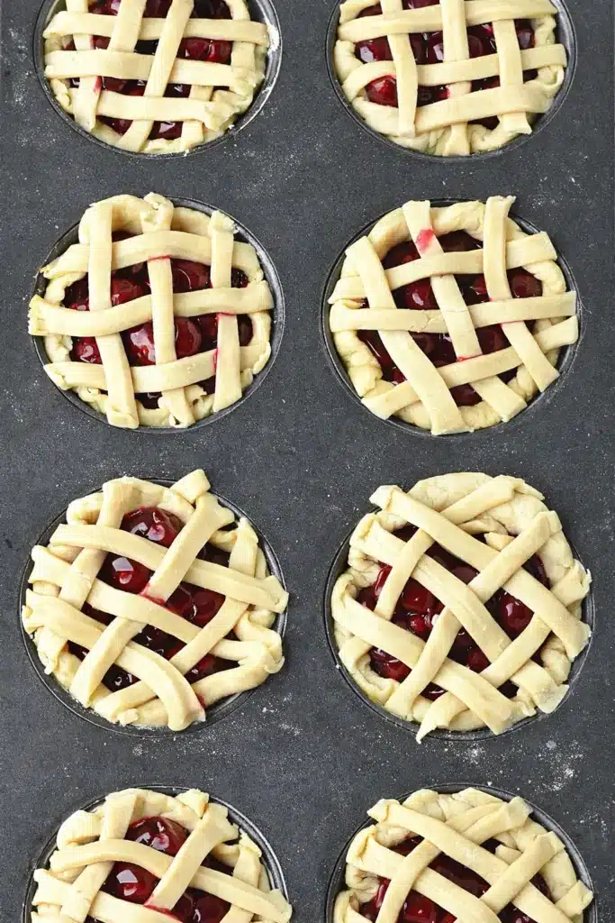 Mini Cherry Pies in muffin pan with lattice crust before baking