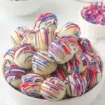 Patriotic Oreo balls with white chocolate coating and red blue drizzle in bowl