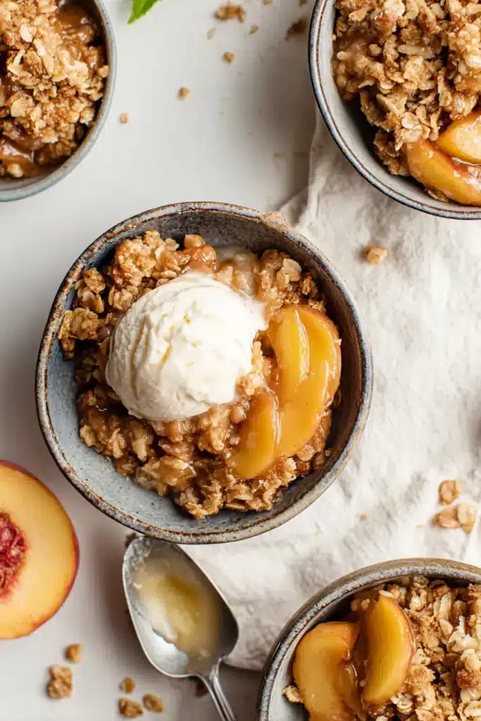 Peach crisp recipe with ice cream in bowls overhead