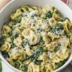 Pesto tortellini with spinach and parmesan in a white bowl