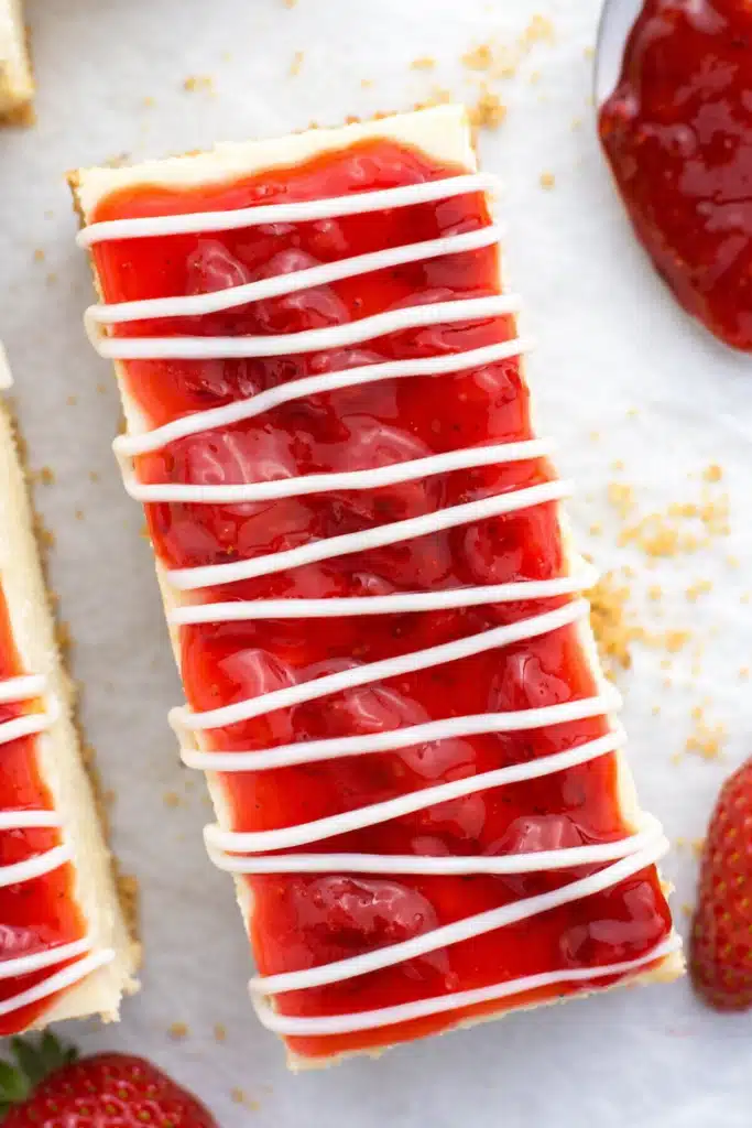 Philadelphia cheesecake bars with strawberry topping in a modern outdoor setting
