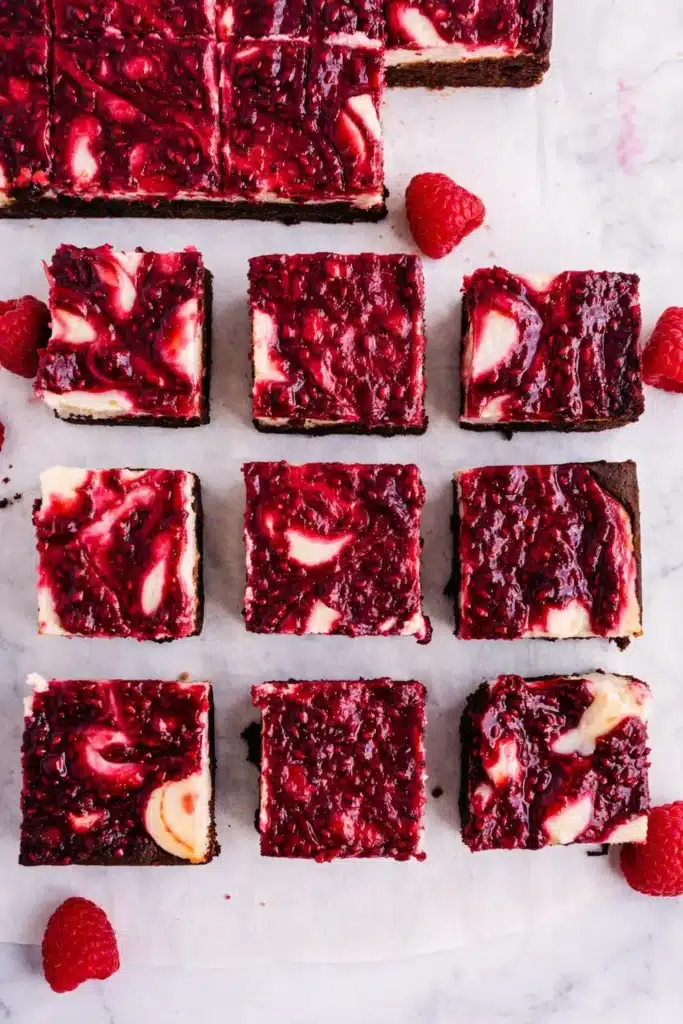 Raspberry Cheesecake Brownies Irresistible Treat 5 Raspberry Cheesecake Brownies cut into squares with glossy raspberry topping