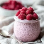 Raspberry chia pudding in a jar topped with fresh berries healthy breakfast