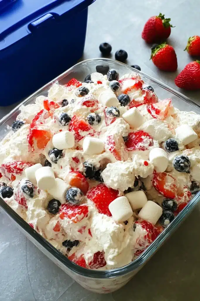 Red White and Blue Cheesecake Salad with strawberries blueberries and marshmallows in creamy mixture