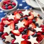 Red white and blue fruit salad with berries and star-shaped pears in festive summer bowl