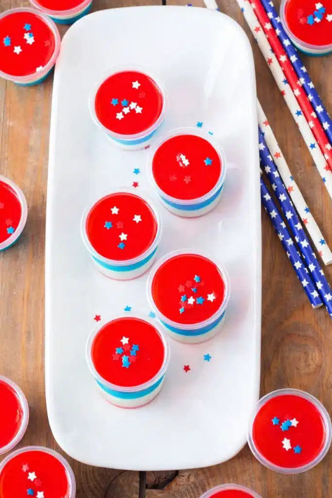 Patriotic layered jello shots with red white and blue layers and star sprinkles