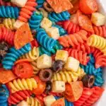 Red white and blue pasta salad with rotini, mozzarella, tomatoes, and olives