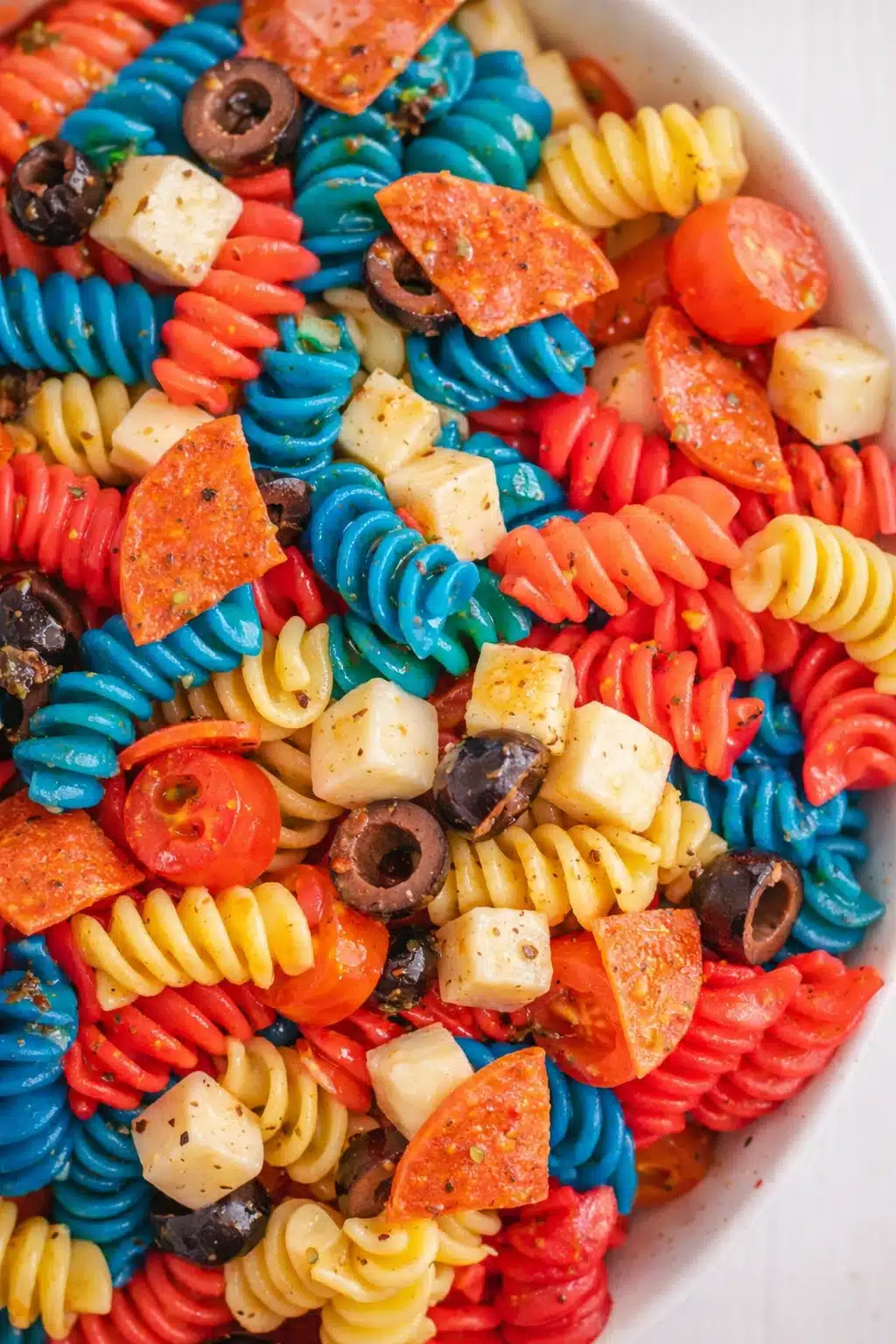 Red white and blue pasta salad with rotini, mozzarella, tomatoes, and olives