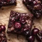 Fudgy roasted chocolate cherry brownies with glossy cherries and melted chocolate chips
