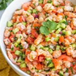 Fresh shrimp ceviche with avocado, cucumber, and tomatoes in a bowl with tortilla chips