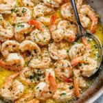 Shrimp scampi in garlic butter sauce with parsley in skillet