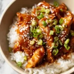 slow cooker chicken thighs with rice and sesame seeds in a bowl