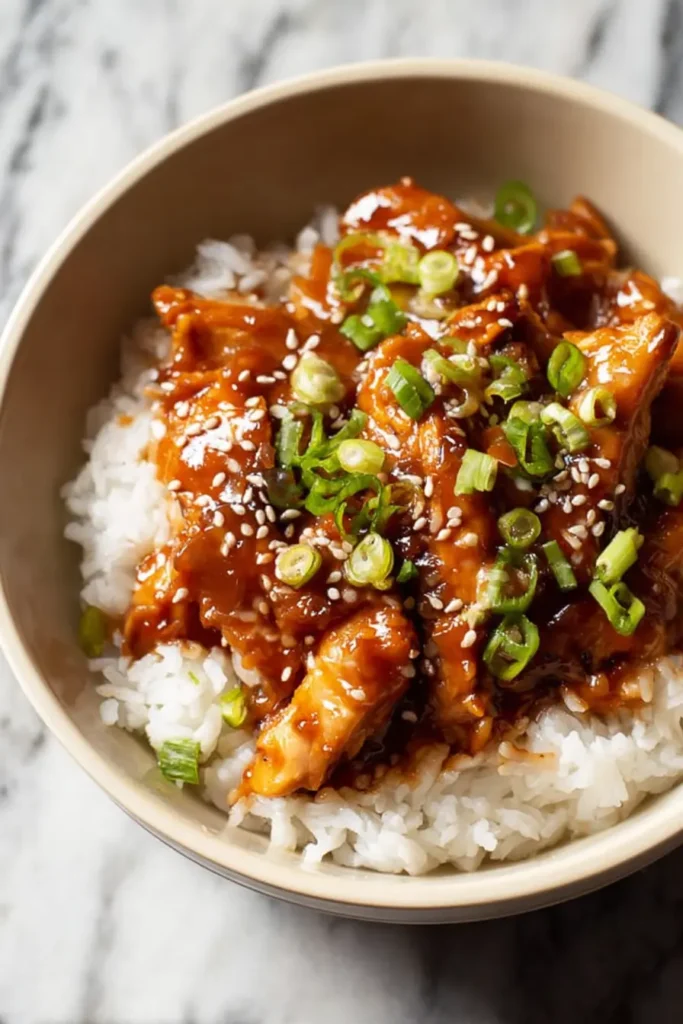 slow cooker chicken thighs with rice and sesame seeds in a bowl
