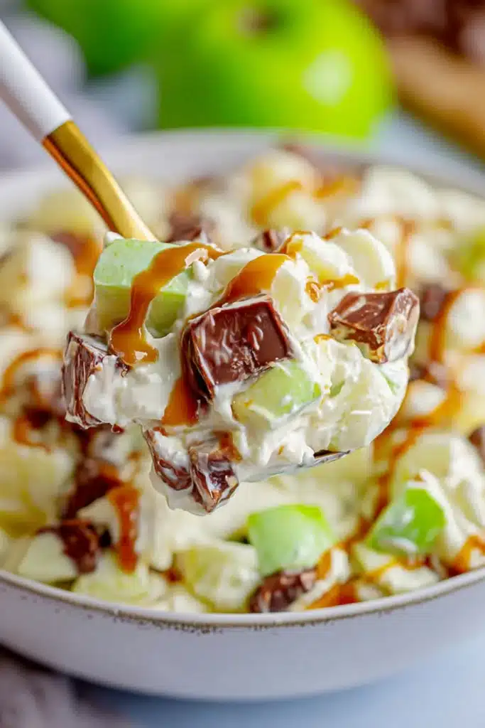 Snickers Salad spoonful with apples, chocolate, and creamy pudding