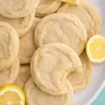 soft lemon sugar cookies with chewy centers and fresh lemon slices on a plate