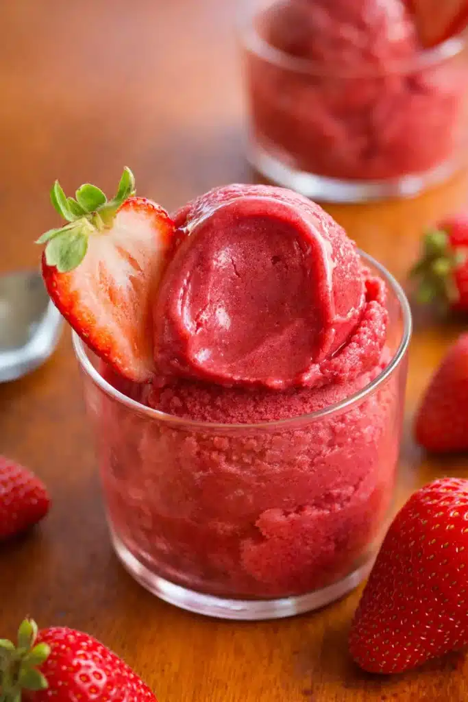 Strawberry sorbet in bowl with fresh strawberries and artistic black white background