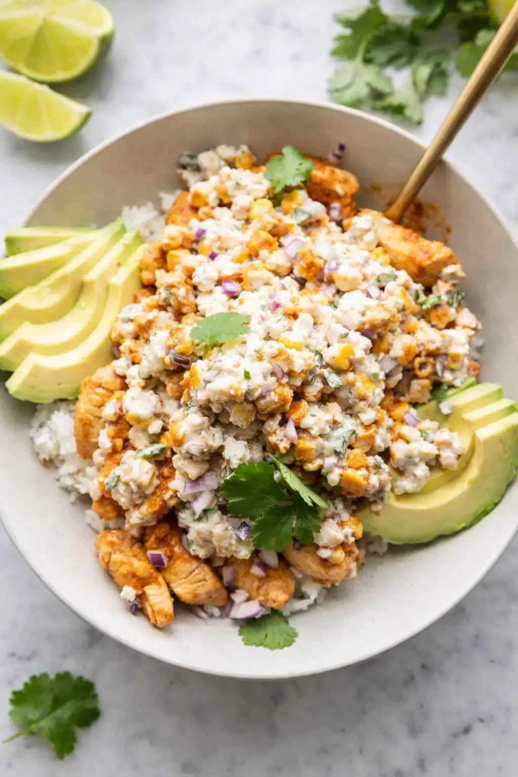 Street corn chicken rice bowl with avocado, creamy corn, and seasoned chicken