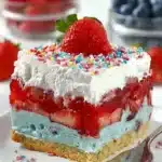 Summer Berry Jello Lasagna slice with layers of cream, strawberries, and whipped topping