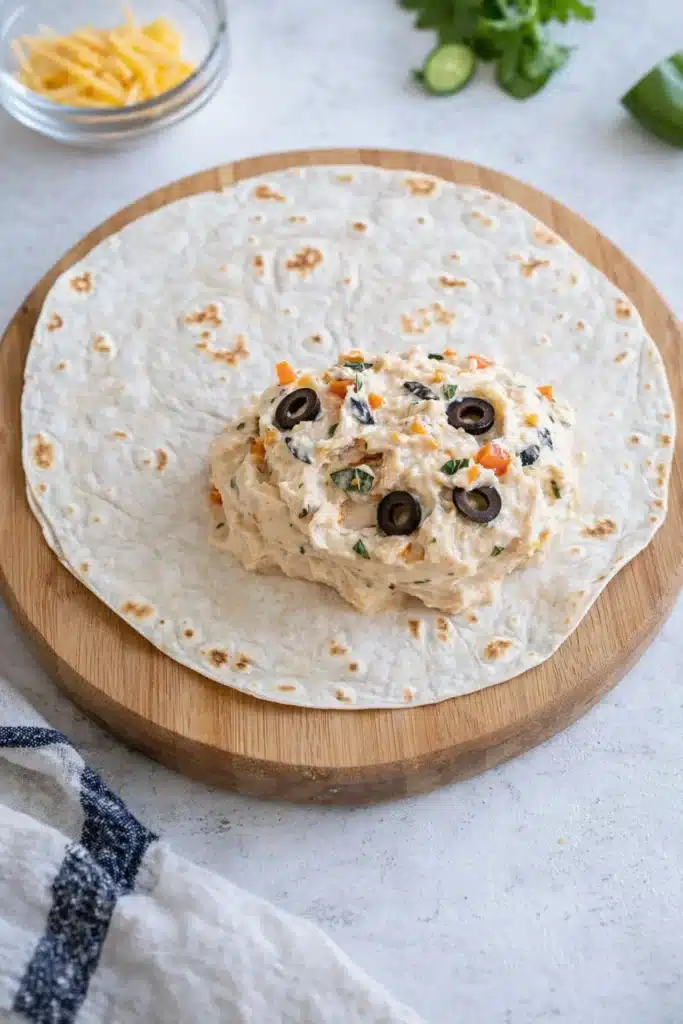 Taco Pinwheels Recipe creamy filling spread on tortilla before rolling