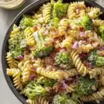 creamy broccoli pasta salad with bacon, rotini, and fresh vegetables in a bowl