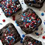 Fudgy 4th of July brownies with red white and blue sprinkles on a festive dessert table