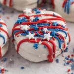 4th of July Oreos dipped in white chocolate with red and blue drizzle and sprinkles