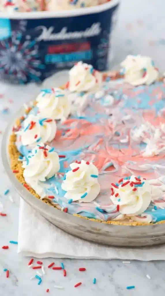 4th of July Ice Cream Pie with patriotic swirls and whipped cream topping